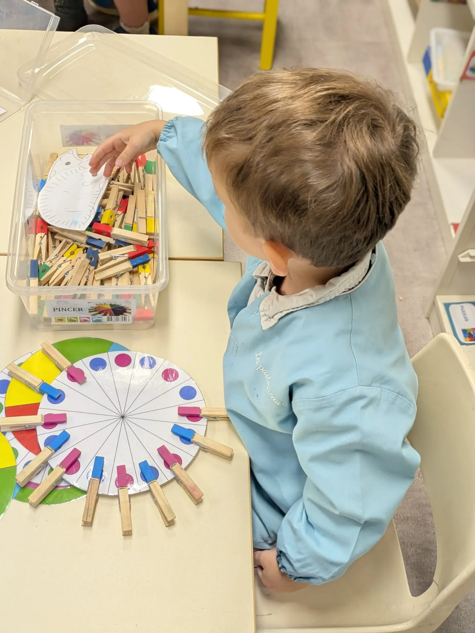 Atelier de motricité fine : des pinces à accrocher sur la roue des couleurs